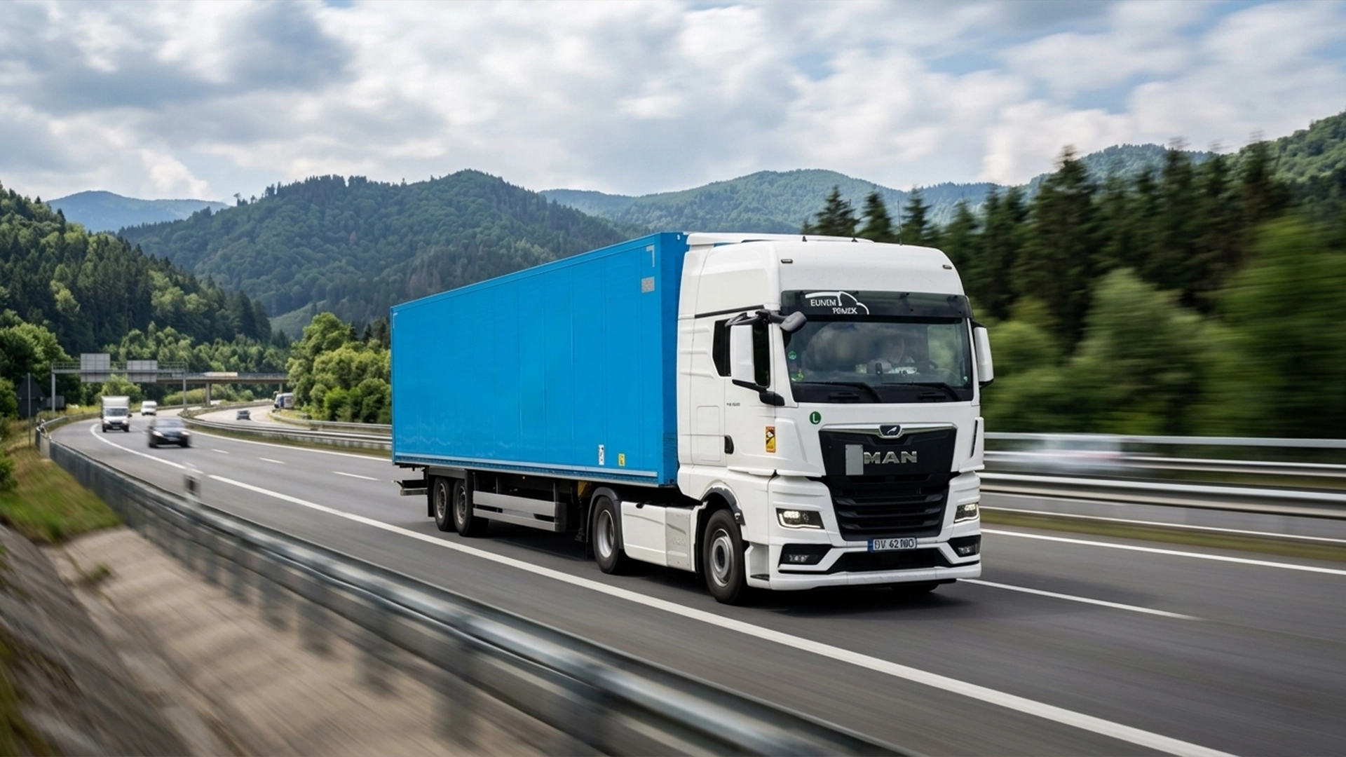 Camion MAN modern si semi-remorca box fotografiate pe autostrada in miscare undeva prin Europa