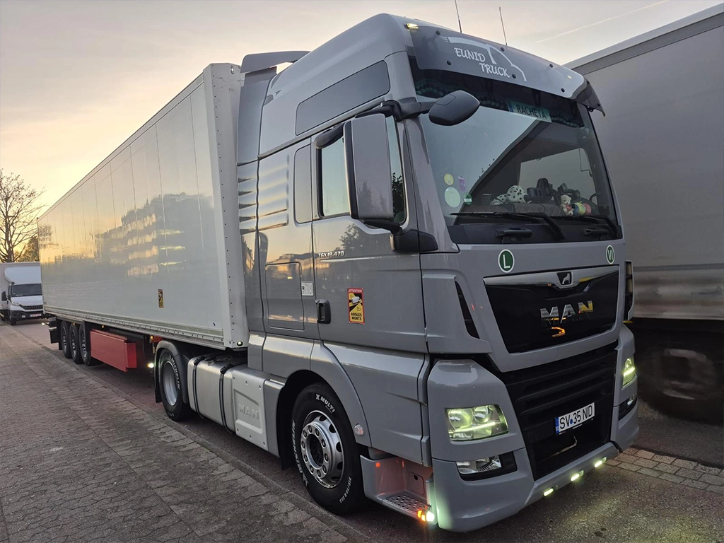 Camion MAN gri si semi-remorca ce sunt folosite la transportul de marfuri international